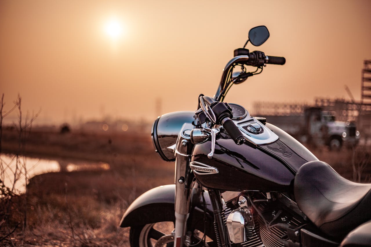 home-img Harley Davidson motorcycle parked outdoors at sunset, capturing the warm glow and serene environment.
